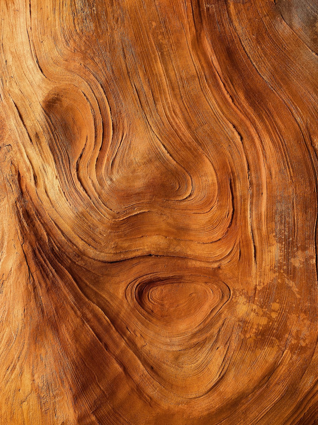 Close-up of intricate swirling patterns in natural wood grain.